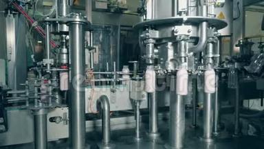 食品工厂输送机的<strong>食品包装</strong>过程。 一台机器在工厂里用牛奶装满瓶子。